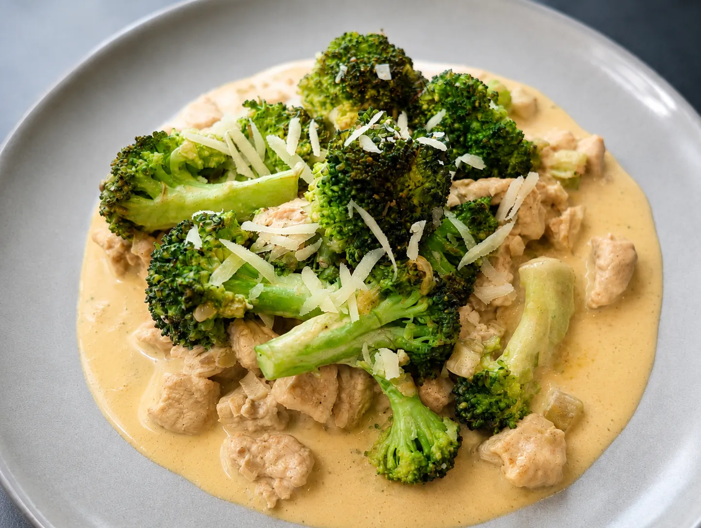 Kyllingestykker og broccoli i en cremet sauce, toppet med revet parmesan.